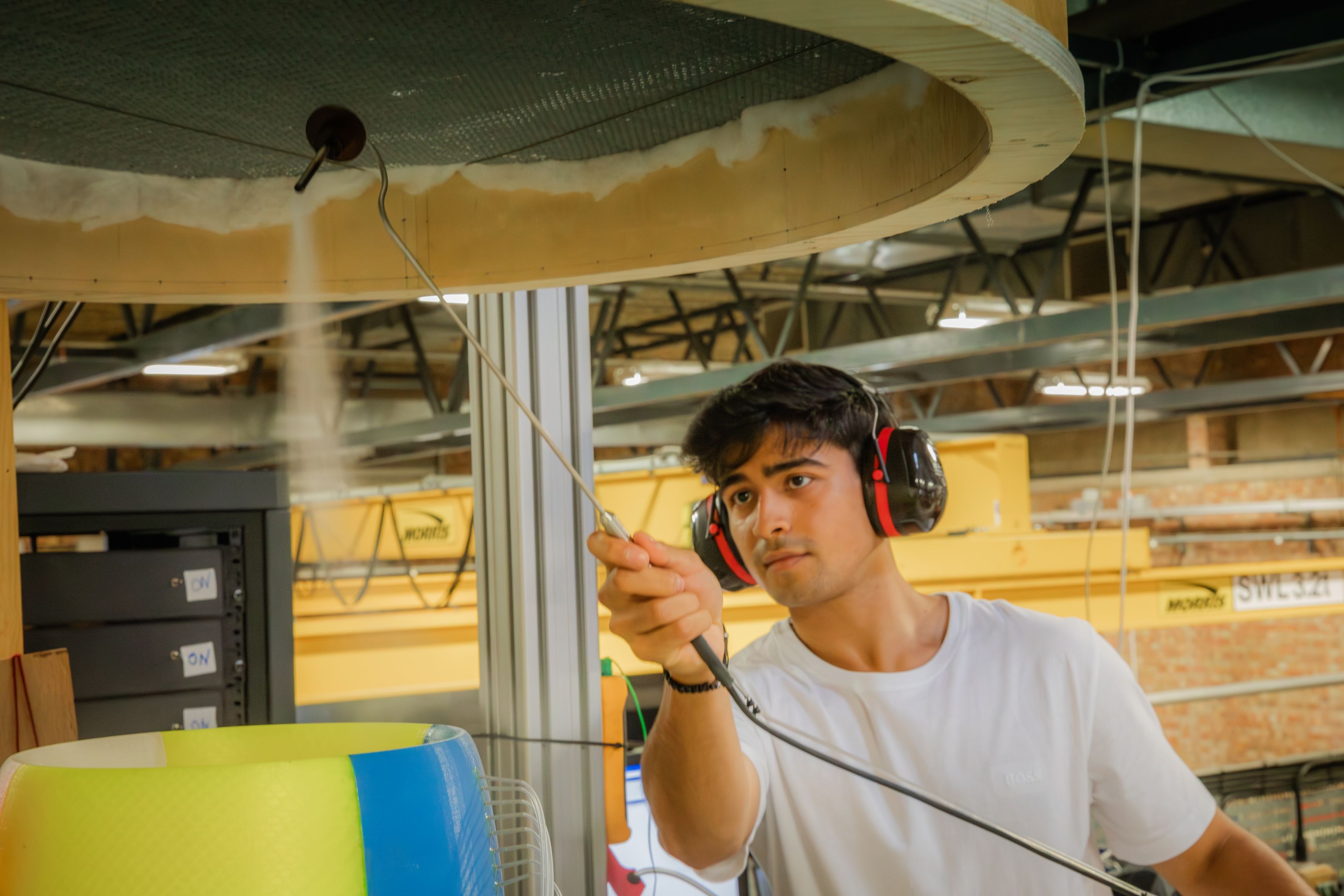 A man wearing a white t-shirt and ear protectors 