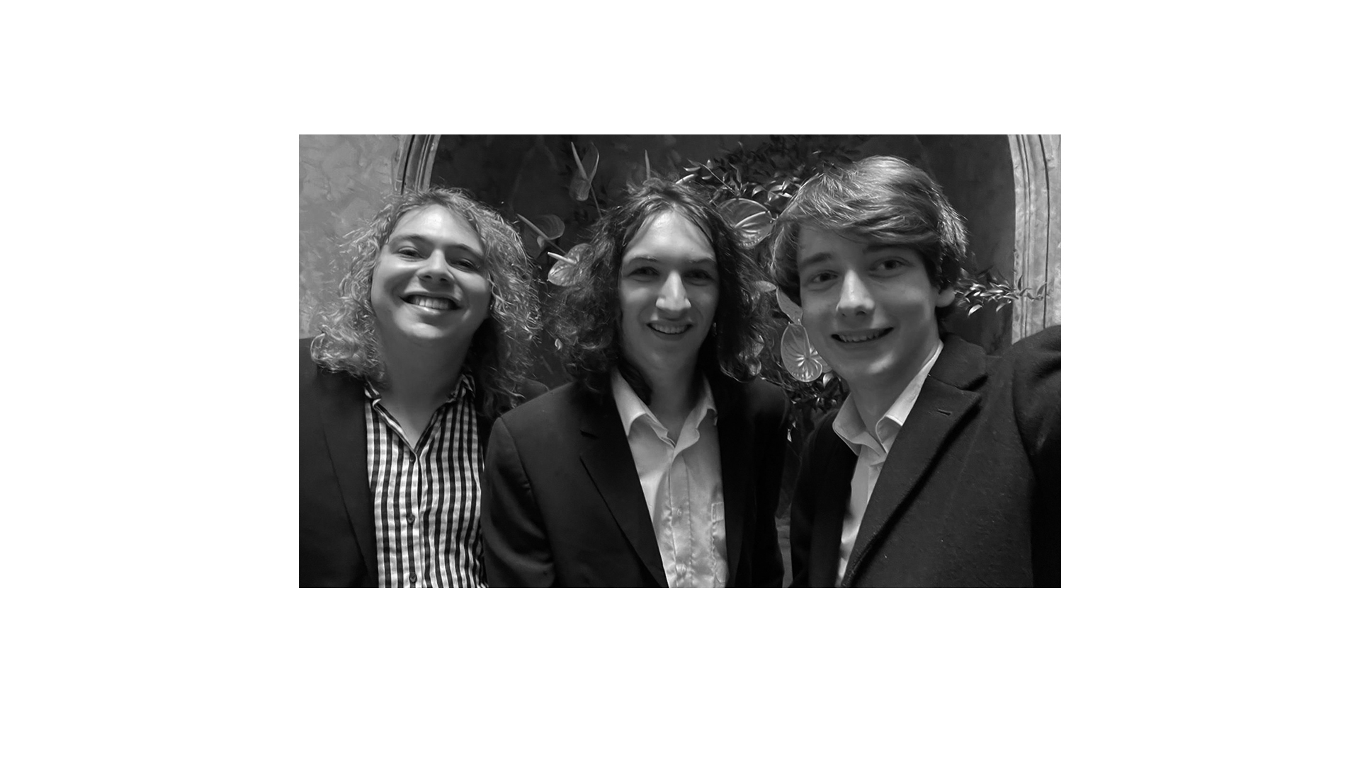 A black and white photo of three smiling Flare team members 