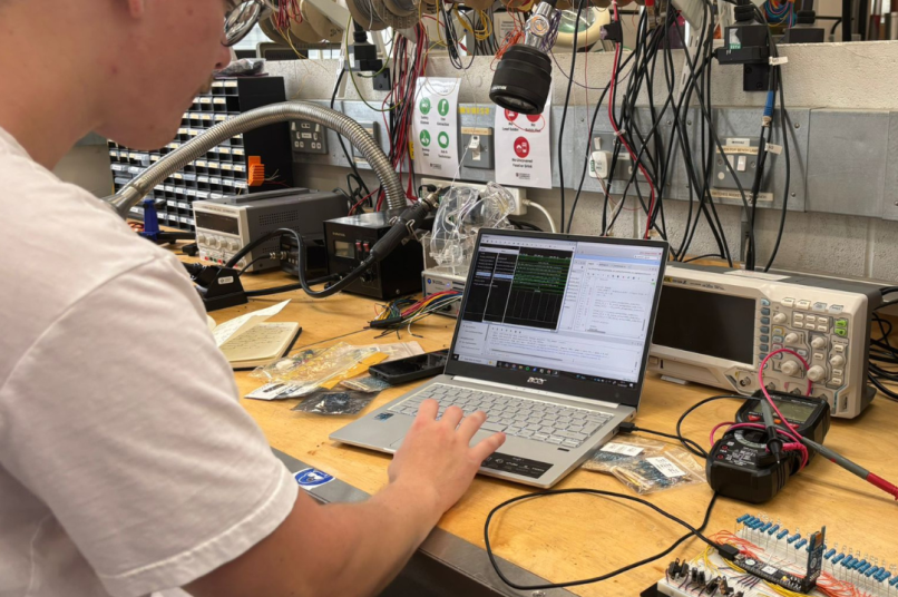 A man working on a laptop in a lab.