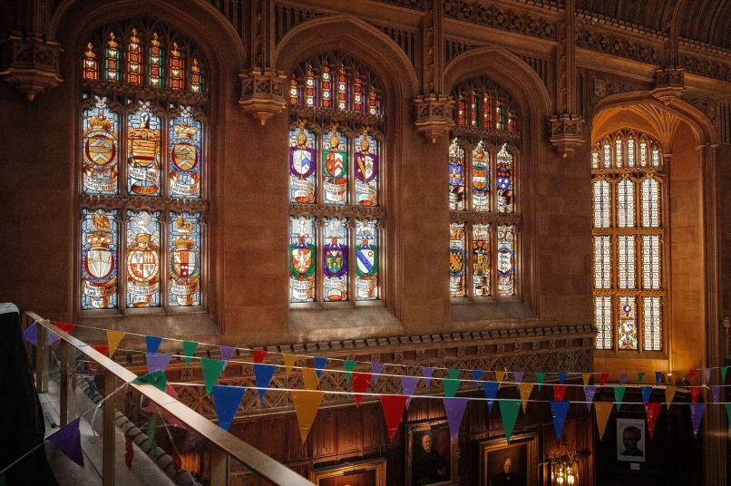Formal hall with stained glass windows and colourful bunting