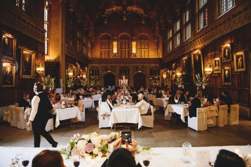 the hall with wedding guests seated at decorated tables