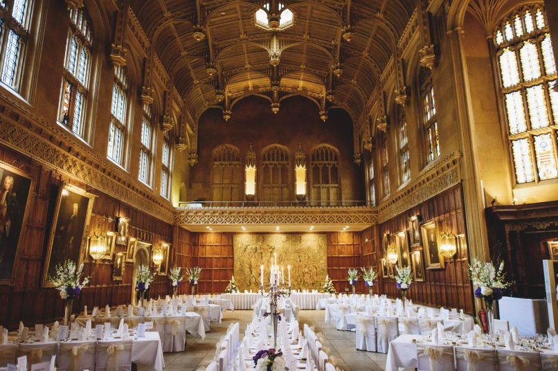 white linen covered tables in a large hall with high ceilings