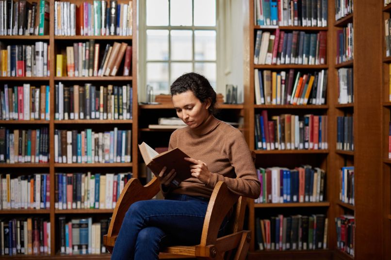 A woman reading a book in the library