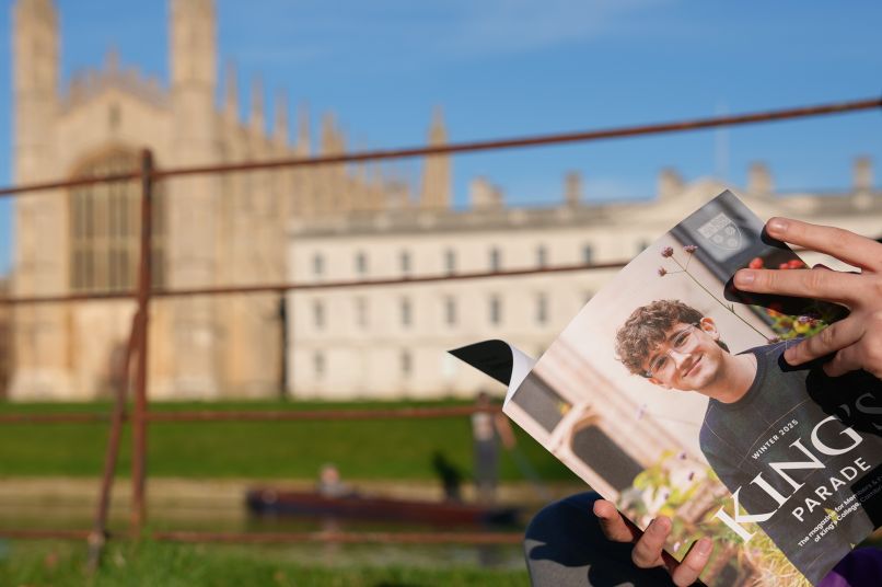A student reading King's Parade with the Chapel and Gibbs behind