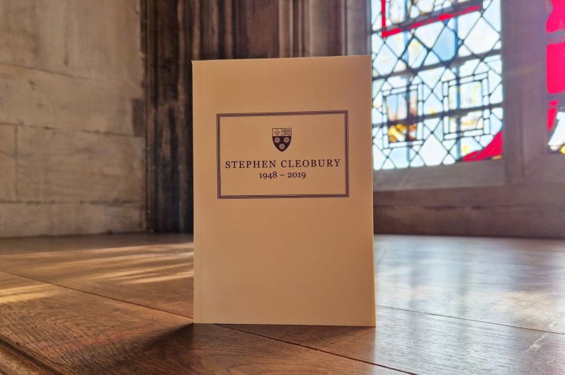 Stephen Cleobury memorial booklet in Chapel on a wooden ledge next to a stained glass window