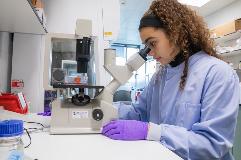 A student looking through a microscope