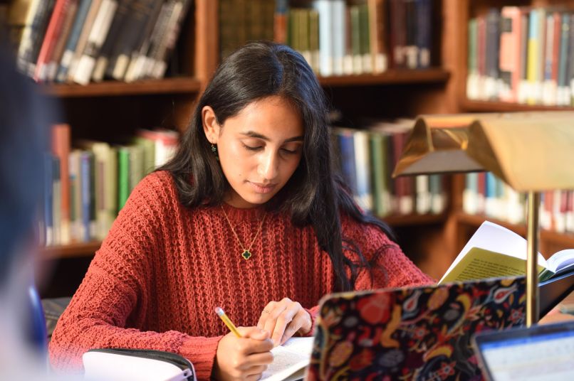 female graduate student working in library
