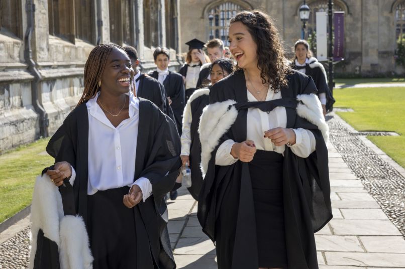 smiling female students wearing graduation robes