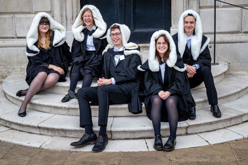 Students smiling in graduation gowns
