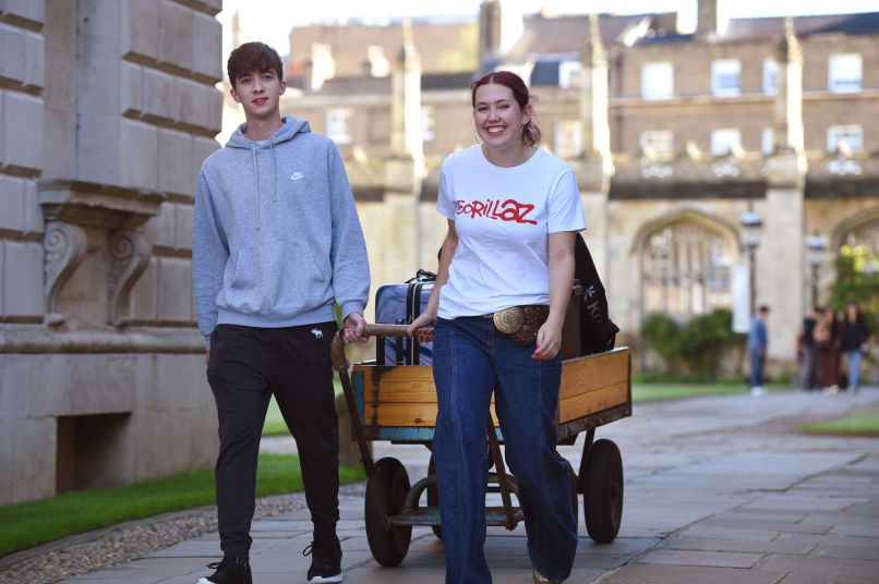 a male student and female student with a luggage trolley
