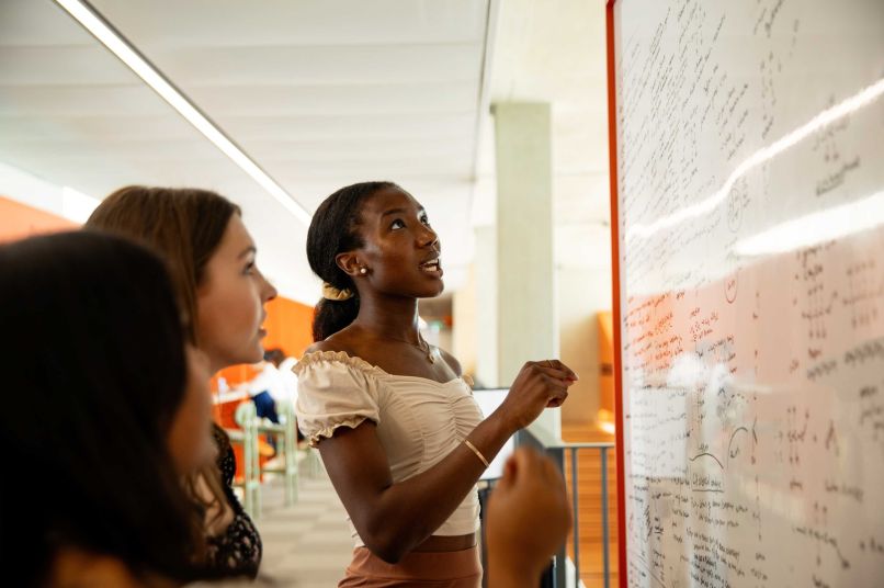 Students working on a whiteboard together
