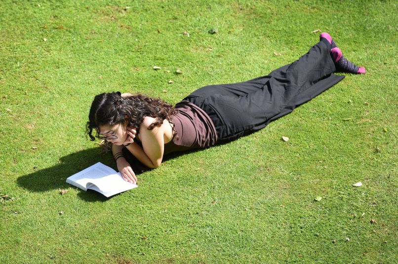 Student lying on the ground reading