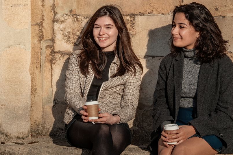 Two students smiling with coffee