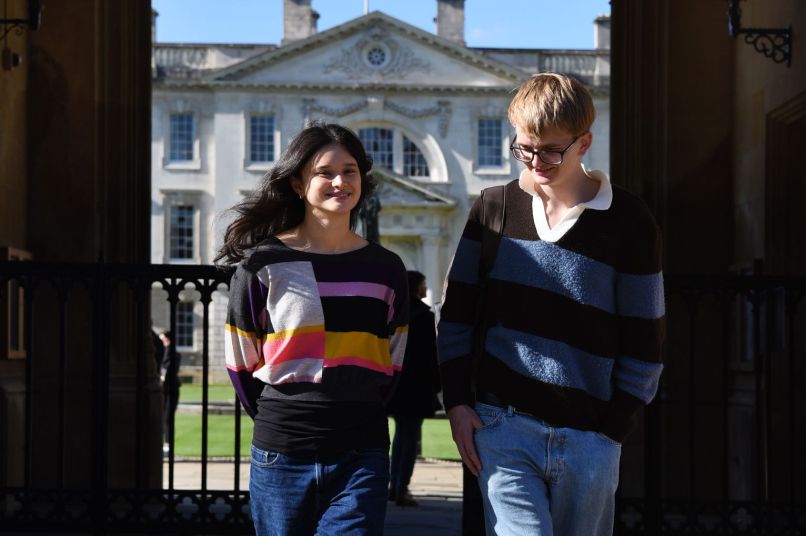 Two students walking through King's front gate