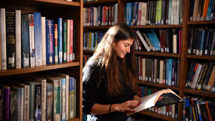 female-student-reading-a-text-book-in-the-library