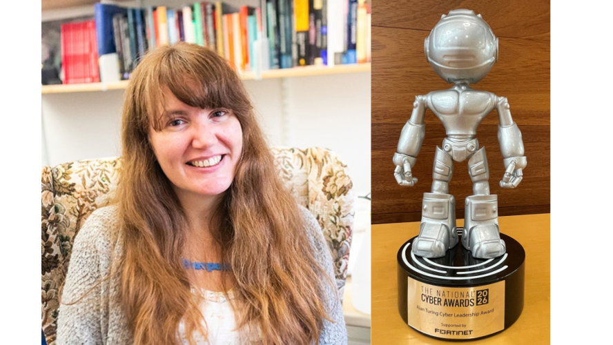 A white woman with long hair next to a small statue of a robot