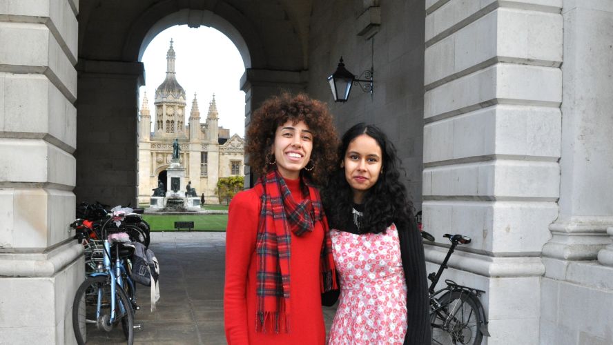 two students standing under an archway