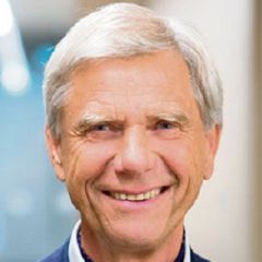 Smiling man with grey hair in a blue suit