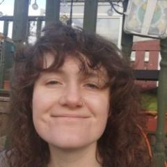 A smiling woman with dark curly hair.