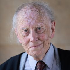 John Dunn, a smiling man with a black blazer and blue shirt