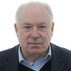 Gareth Austin, a man with short hair wearing a dark suit and a blue shirt facing the camera