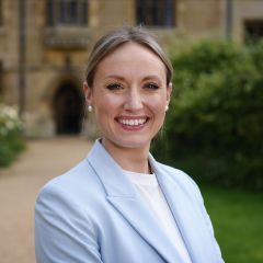 A white woman with gardens in the background