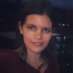 Andjela Sarkovic, a smiling woman with dark hair and a maroon jumper. 