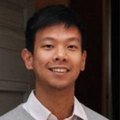 Apinan Hasthansombat, a smiling man with short dark hair wearing a grey sweater and a white shirt