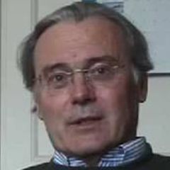 Barry Keverne, a man with grey hair and glasses wearing a striped shirt and a dark jumper