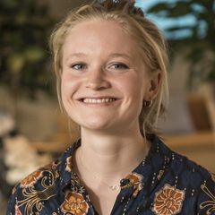 Coco Newton, a smiling woman with blonde hair wearing a blue and orange floral shirt