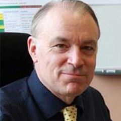 Gareth Austin, smiling man with short hair wearing a blue suit and a yellow tie