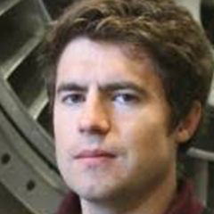 James Taylor, a man with short brown hair wearing a maroon polo-shirt. He is standing in front of a piece of machinery 