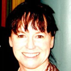 A smiling woman with dark tied back hair and a fringe.