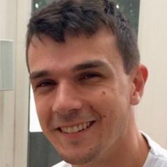 Mark Dyble, a smiling man with short dark hair and a white t-shirt