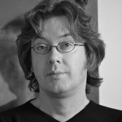 Matthew Gandy, a black and white photo of a mad with mid length hair and glasses