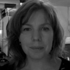 A black and white image of a smiling woman with mid length hair
