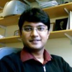 Ronojoy Adhikari, a smiling man with dark hair and glassed wearing a black jumper
