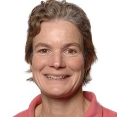 Sarah Lummins, a smiling woman with short brown hair and brown eyes wearing a pink polo shirt against a white background