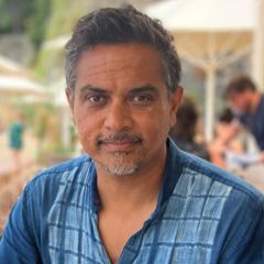 Sharath Srinivasan, a smiling man with dark grey hair wearing a casual blue shirt.