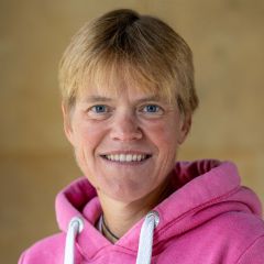 A white woman with blond hair and a pink hoodie