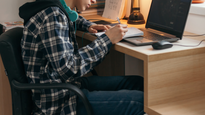 Young man writing on a notebook