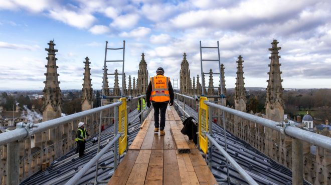 A construction worker on King's College Chapel roof with safety equipment