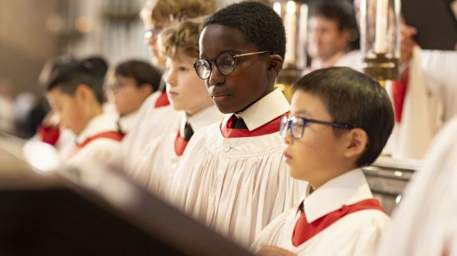 a group of choristers in white and red robes