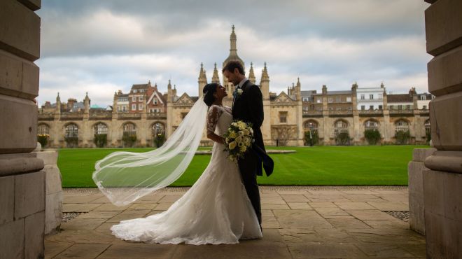 bride and groom with lawn and fountain behind them