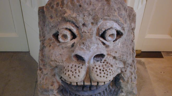 a stone lion head mounted on a plinth