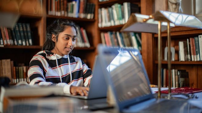 Student in the Library working at her laptop