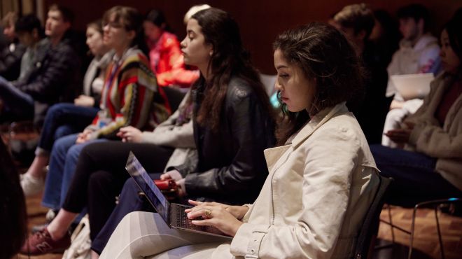students in a lecture theatre with open laptops