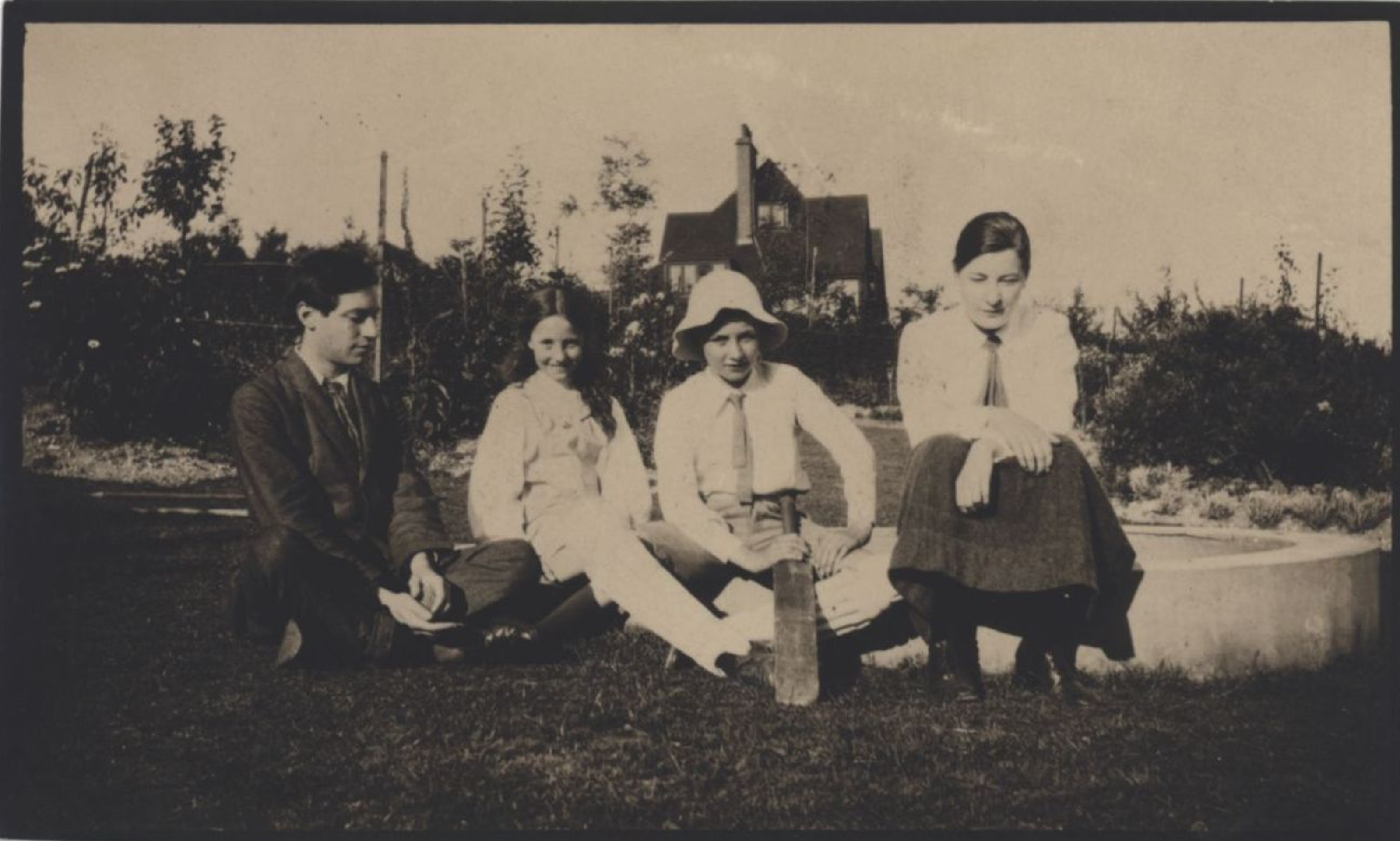 Snapshot of Duncan Grant, Pamela and Julian Fry and Troth Swinburne sitting on the lawn at Durbins, 1910. [REF/6/8]