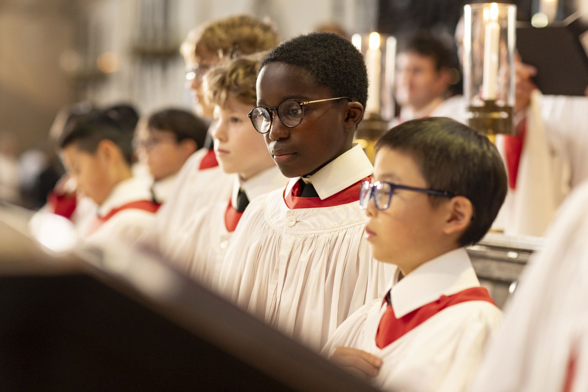 a group of choristers in white and red robes