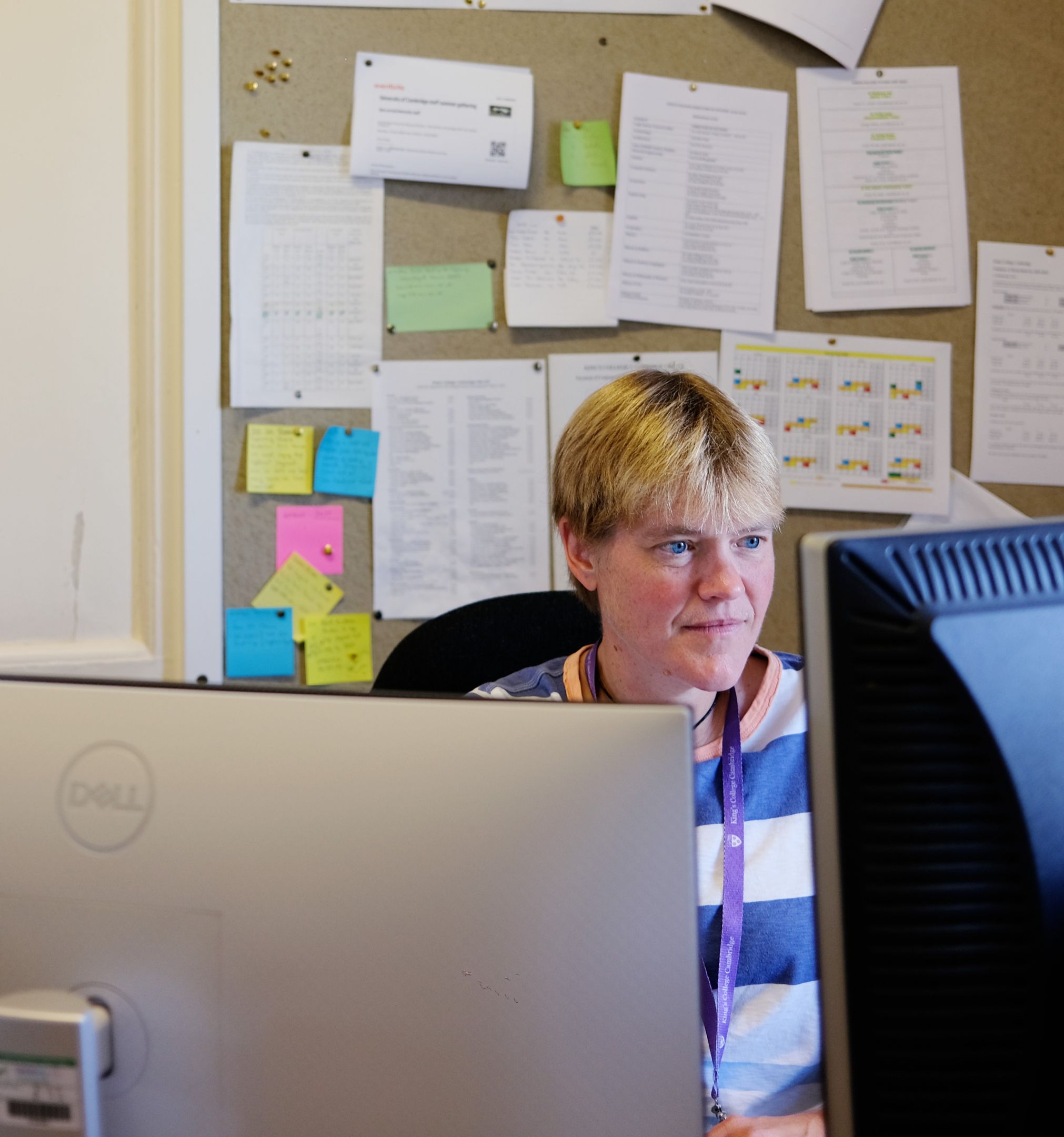 A woman sat at her desk looking at one of her computer screens